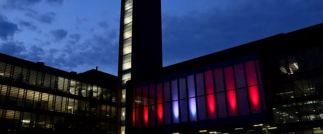 A view of Vaughan City Hall's Council chambers illuminated from the outside.