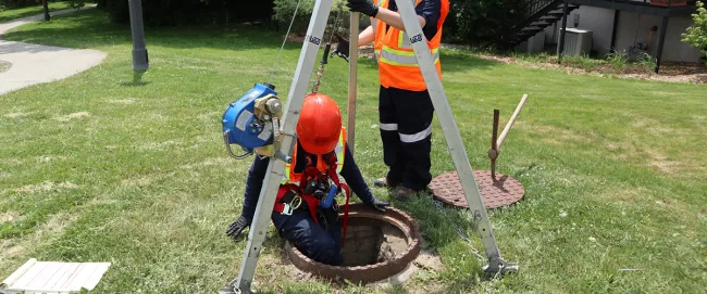 A person descending down into the sewer.