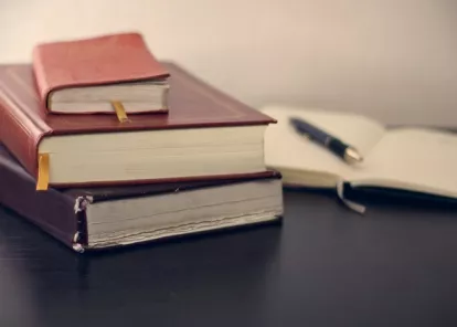 stack of heavy books on a desk or tabletop