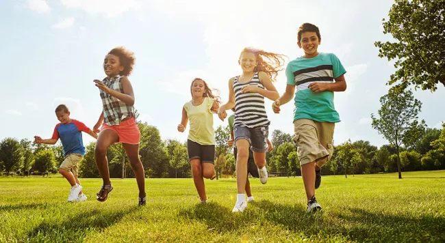 kids running in a field on a sunny day.