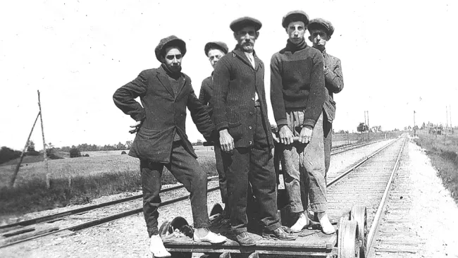 Five men standing on train tracks in the Village of Nashville