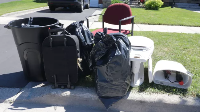 garbage bags, toilet, chair at the curb