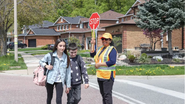 Children crossing the street with a crossing guard