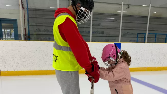 a coach and young student skating