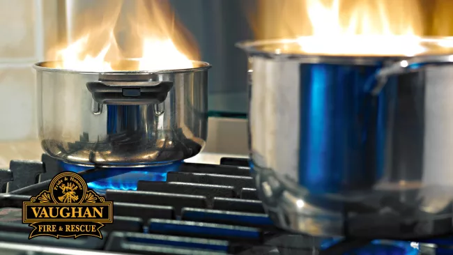 Pots on fire on top of a stove.