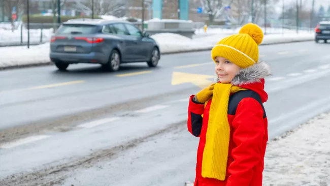 Little kid waiting to cross the road