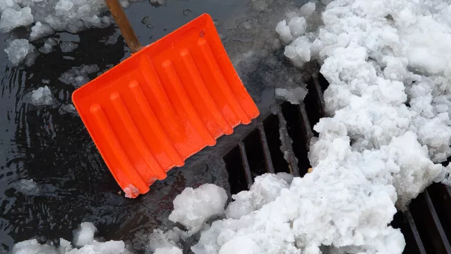 shoveling snow off a catch basin