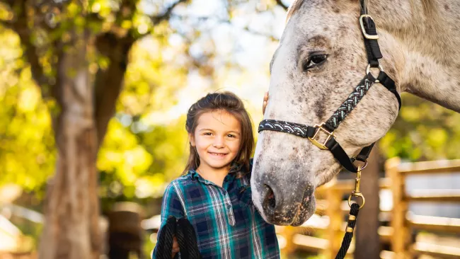 Girl standing with a white horse