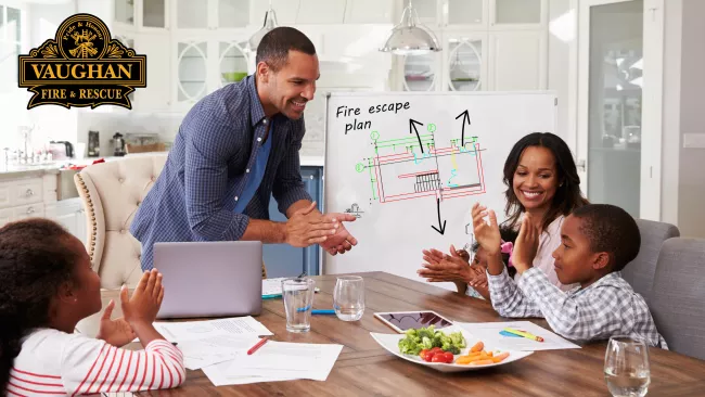 Family sitting around the kitchen table making their home escape plane