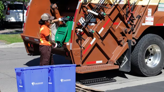 a Miller Waste collector holding a green bin