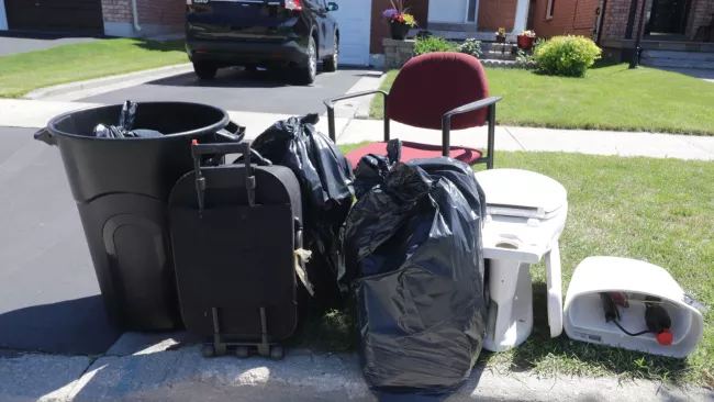 garbage bags, toilet, chair at the curb