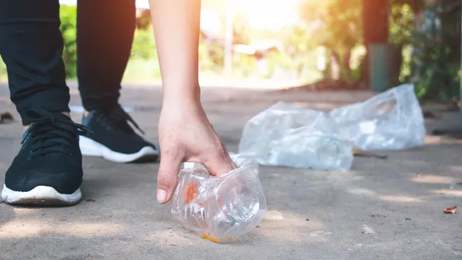 Someone picking up garbage on a trail