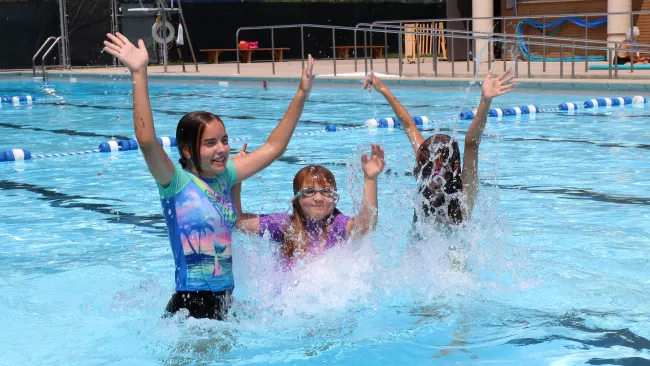 Three girls having fun in the outdoor pool. 