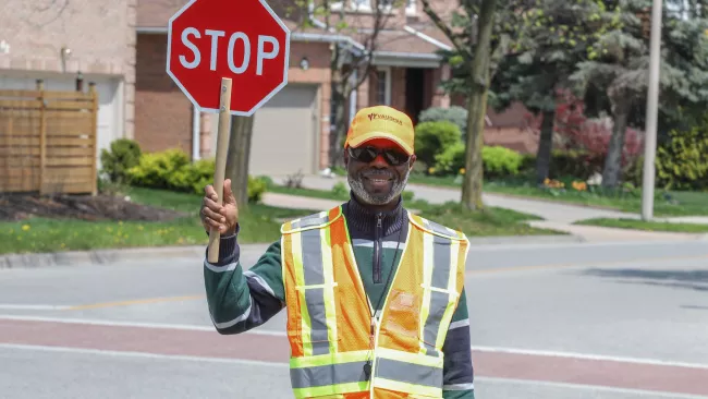 A school crossing guard at his post holding a stop sign