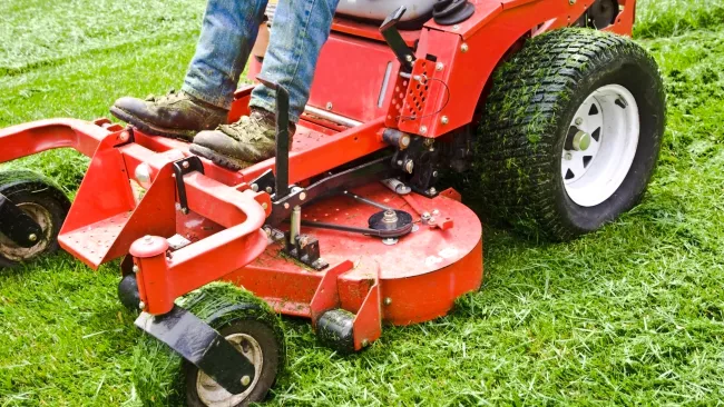 Person on a riding lawnmower cutting the grass