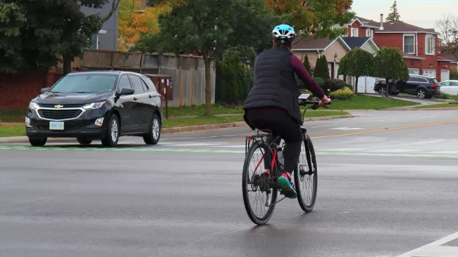 Cyclist with car on the road 