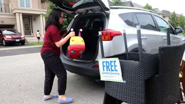 someone placing a child's toy in their car