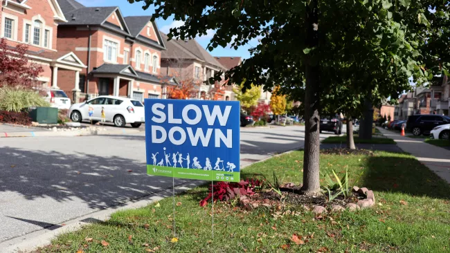 Slow Down Vaughan sign on a boulevard