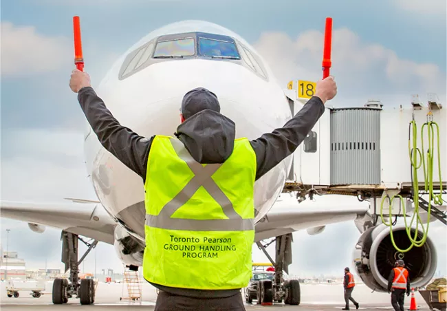 A man marshalling an aircraft on the ground