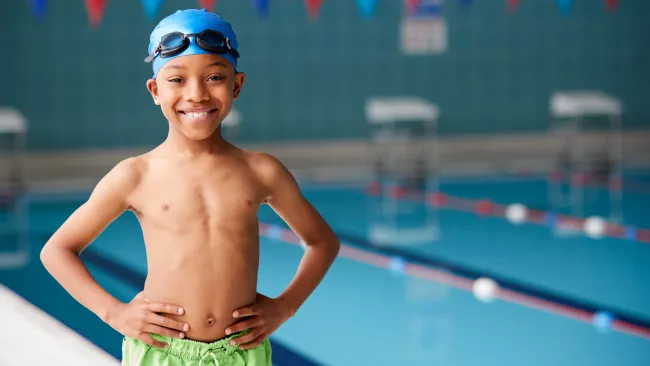 Boy standing by indoor pool