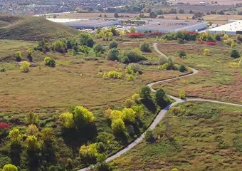 Aerial image of North Maple Regional Park showing a pathway through greenspace and facilities in the background