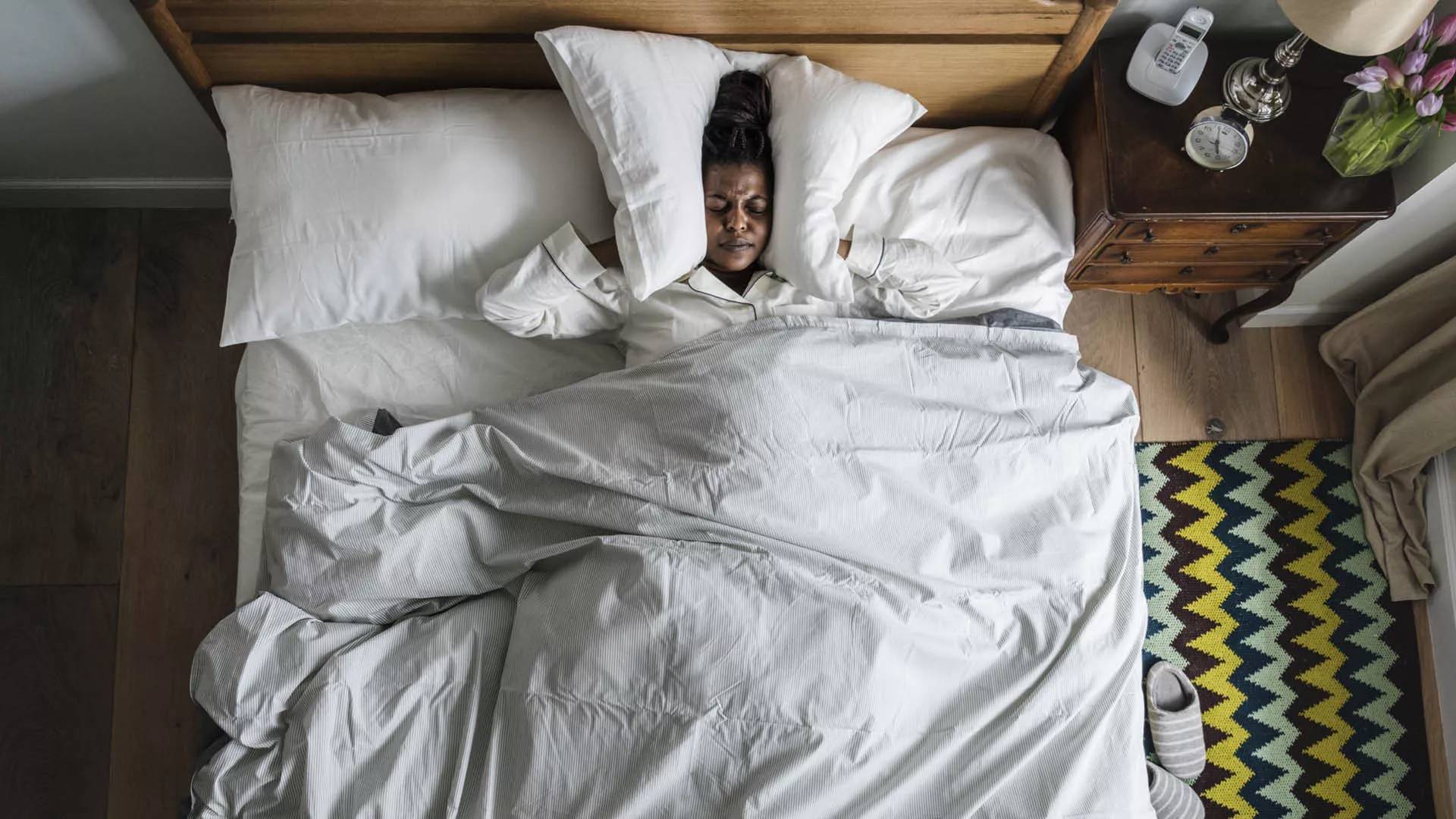 Person in bed listening to loud noises