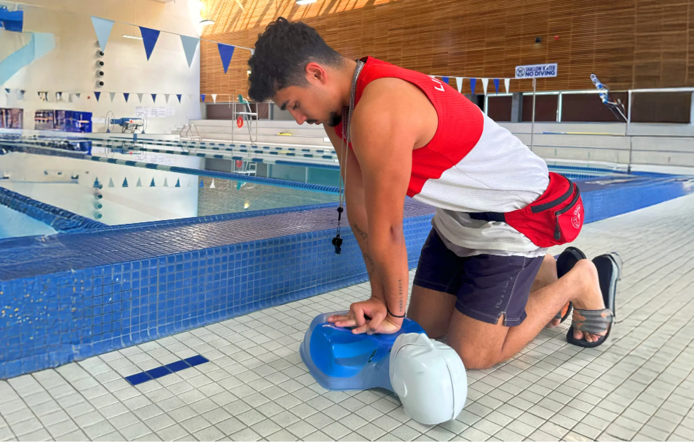 A lifeguard performing CPR on a resuscitation manikin